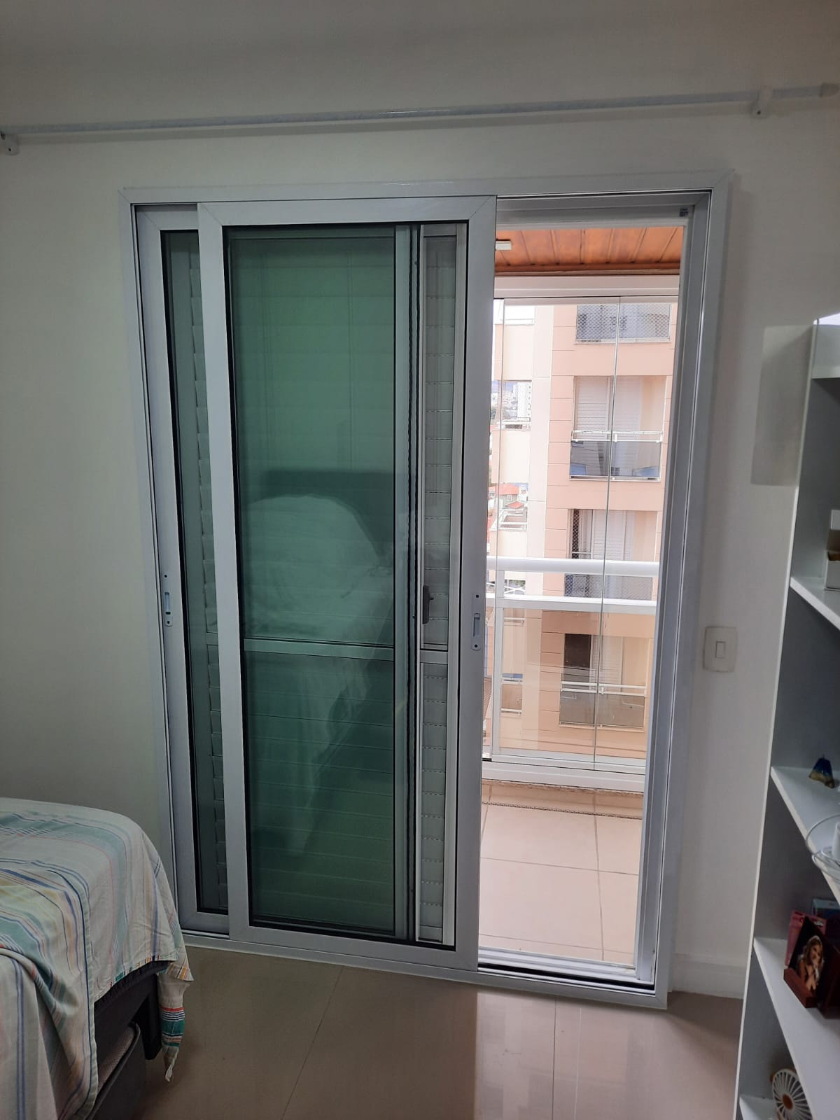Porta de alumínio branca instalada em ambiente interno.